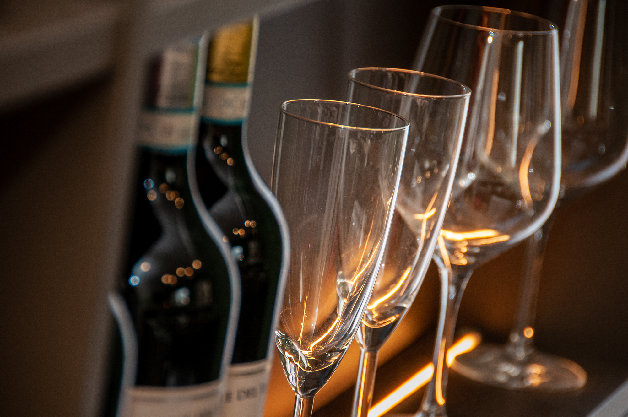 Crystal flutes backlit at the bar